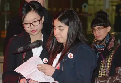  ?? CATHIE COWARD, THE HAMILTON SPECTATOR ?? Labika Ghani, right, of Sir John A. Macdonald Secondary School and Ashley Yu of Ancaster High School, who are members of the Young Women’s Advisory Council, read out the names of the 14 victims of the Montreal Massacre at a gathering to mark the 25th...