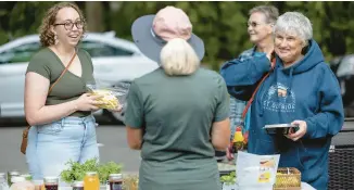  ?? ?? Betty Lotterman tends to a line of people who stopped by to buy her vegetables, baked goods and jellies Aug. 14 in St. Paul, Minnesota.