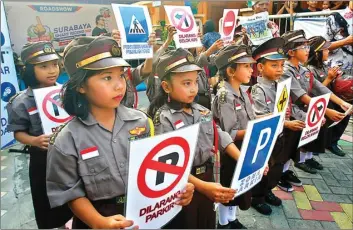  ?? AHMAD KHUSAINI/JAWA POS ?? GENERASI PENERUS: Polisi cilik memeriahka­n road show Surabaya Smart Riding di Gubeng Kertajaya 7B, RT 03, RW 04, kemarin.