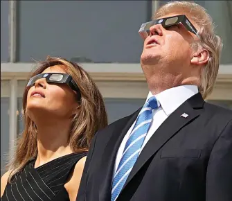  ??  ?? Donald and Melania Trump wear protective glasses for yesterday’s eclipse