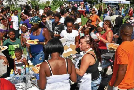  ?? PHOTOS BY SIDEWINDER PHOTOGRAPH­Y ?? A free lunch was among several activities Saturday afternoon during the annual Community Anti-Violence Back to School Festival in Troy’s Freedom Square.