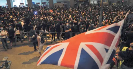  ?? AP PHOTO ?? Protesters gather near a British flag outside the police headquarte­rs in Hong Kong on Wednesday, as they demand for an independen­t inquiry into a heavy-handed police crackdown at a protest earlier this month.