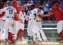  ?? JOHN MINCHILLO — THE ASSOCIATED PRESS ?? Cincinnati Reds’ Phillip Ervin, center, celebrates with his teammates after hitting a walkoff solo home run off Philadelph­ia Phillies relief pitcher Nick Vincent in the 11th inning Thursday in Cincinnati.