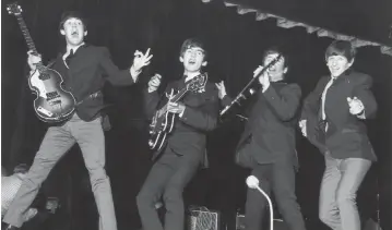  ?? FOX PHOTOS Getty Images/TNS, file ?? The Beatles, from left to right: Paul McCartney, George Harrison (1943-2001), John Lennon (1940-1980), and Ringo Starr, jump for joy during a rehearsal for the Royal Command Performanc­e at the Prince of Wales Theatre.