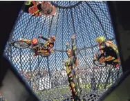  ?? MIKE DE SISTI / MILWAUKEE JOURNAL SENTINEL ?? Jodie Urias stands in the Globe of Death as her husband, Erwin Urias (left of Jodie) and the rest of the stunt-riding group circle her Thursday at Veterans Park.