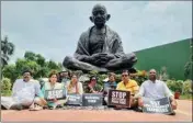  ?? ?? Trinamool Congress MPs — who were suspended on Tuesday over ‘unruly behaviour and disrupting proceeding­s on Wednesday— staged a sit-in protest at the Gandhi statue outside Parliament on Wednesday