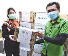  ??  ?? Hospital Labuan staff receives medical and food supplies from Shell.