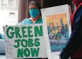  ?? Ed Zurga / Getty Images for Green New Deal Network ?? Sheri Tindle holds a sign in support of President Joe Biden’s $2.2 trillion infrastruc­ture plan this week in Kansas City, Mo.