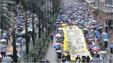  ?? REUTERS ?? Anti-government protesters carry a banner during a demonstrat­ion in Wan Chai district in Hong Kong, China yesterday.