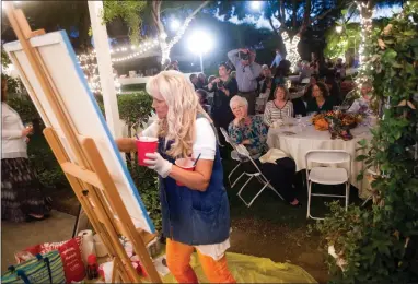  ?? RECORDER PHOTOS BY CHIEKO HARA ?? Artist Jonell Mauck paints live as captivated guests look on Saturday, Oct. 13 at the Portervill­e Art Associatio­n’s ‘A Night To Remember’ fundraiser event at Nuckols Ranch.