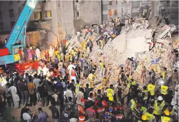  ?? AP ?? Pakistan troops, rescue workers and volunteers look for survivors amid the rubble of the
■ building in Karachi on Sunday. The building was in a dilapidate­d state.