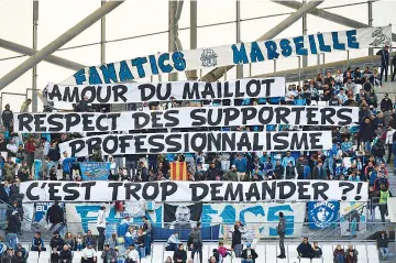  ?? — AFP photo ?? Olympique de Marseille (OM) fans hold a banner reading “for the love of the OM jersey, the respect of fans and profession­alism, is it too much to ask?”, prior to the start of the French L1 football match between Olympique de Marseille (OM) and Caen at...