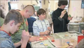  ?? / John Popham ?? Berry Middle School eighth-graders Daniel Donadio (from left), Ben Cook, Samuel Fricks and Chase Lundsberg are busy Tuesday glazing ornaments.