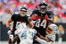  ?? Todd Kirkland / Getty Images ?? Cordarrell­e Patterson (84) of the Falcons is tackled by Michael Davis (43) and Austin Johnson of the Chargers.