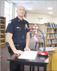  ?? LYNN KUTTER ENTERPRISE-LEADER ?? Cpl. David Faulk, a Prairie Grove school resource officer, turns the pages while his partner is reading a children’s book. The two officers are recording themselves reading books and then posting the videos on their Prairie Grove School Resource Officer Facebook page.