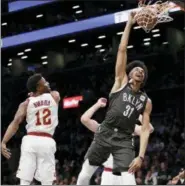  ?? KATHY WILLENS — ASSOCIATED PRESS ?? David Nwaba watches as Nets center Jarrett Allen dunks during the first half March 6 in New York.