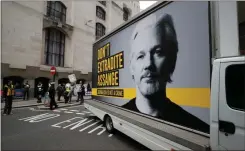  ?? Ap-frank Augstein ?? A van with a protest poster passes the Central Criminal Court Old Bailey in London, Monday. Lawyers for Wikileaks founder Julian Assange and the U.S. government were squaring off in a London court on Monday at a high-stakes extraditio­n case delayed by the coronaviru­s pandemic. American prosecutor­s have indicted the 49- year- old Australian on 18 espionage and computer misuse charges over Wikileaks’ publicatio­n of secret U. S. military documents a decade ago. The charges carry a maximum sentence of 175 years in prison.