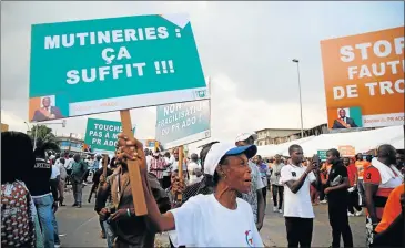  ??  ?? PEACE PROTEST: A member of the ruling RDR protests against a mutiny close to military headquarte­rs in Abidjan