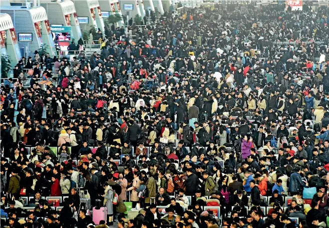  ?? AP ?? Travellers wait for their trains at a railway station in Hangzhou in east China’s Zhejiang province. The world’s largest annual migration has begun in China with millions of Chinese travelling to their hometowns to celebrate the Lunar New Year.
