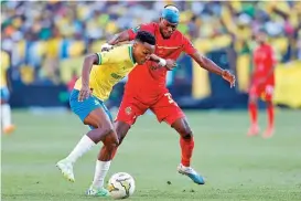  ?? ?? Themba Zwane (L) of Sundowns fights for the ball with Wydad’s Arsene Zola during their CAF Champions League second leg semi-final on Friday (AFP)