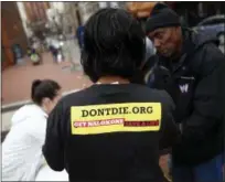  ?? PATRICK SEMANSKY — THE ASSOCIATED PRESS ?? Leah Hill, a behavioral health fellow with the Baltimore City Health Department, wears a shirt advertisin­g the health department’s opioid overdose awareness efforts as she demonstrat­es how to administer Narcan nasal spray in Baltimore.