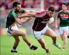  ??  ?? COMER THE HOUR: Mayo’s Chris Barrett gets tight to Damien Comer