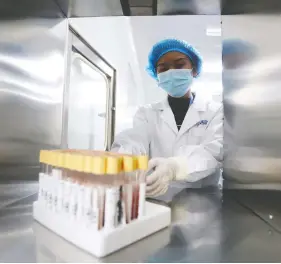  ?? REUTERS / FILE PHOTO ?? A technician works at a genetic testing laboratory of BGI in Kunming, China.
The company has been amassing a large databank of genomic data.