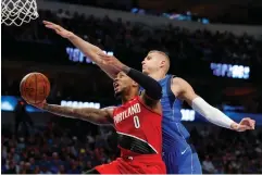  ?? Tony Gutierrez/Associated Press ?? ■ Portland Trail Blazers guard Damian Lillard (0) gets past Dallas Mavericks center Kristaps Porzingis (6) to sink a shot in the second half of an NBA game Sunday in Dallas.