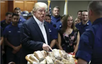  ??  ?? President Donald Trump prepares to hand out sandwiches to members of the U.S. Coast Guard at the Lake Worth Inlet Station, on Thanksgivi­ng on Thursday in Riviera Beach, Fla. AP PHOTO/ALEX BRANDON