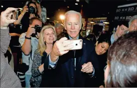  ??  ?? Former vice president and Democratic presidenti­al candidate Joe Biden takes a selfie with a reporter during a campaign stop at the Community Oven in Hampton, N.H., on Monday.