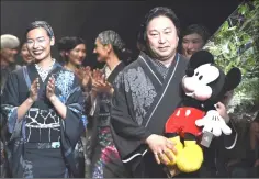  ??  ?? Kimono designer Jotaro Saito (right) greeting the audience at the end of his 2018 autumn/winter collection at Tokyo Fashion Week.