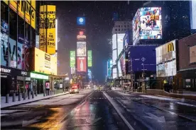  ??  ?? An empty street is seen as snow begins to fall in Times Square during a snow storm, during the coronaviru­s disease in January 2021. Photograph: Jeenah Moon/Reuters