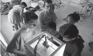  ?? Tribune News Serice ?? From left, Daniel Henderson, Andrew Henderson, Sebastien Carmichael, Bijou Carmichael and Neo Zeinfeld work on repairing a 3D printer during summer school class. The class is called FUSE, and it focuses on getting students to explore science,...