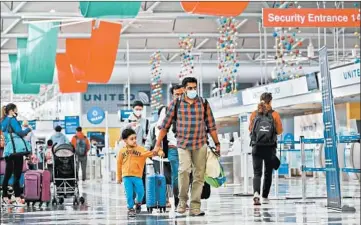  ?? STACEY WESCOTT/CHICAGO TRIBUNE ?? Raj Gungaram holds on to his young son, Rishi Gungaram, as they walk through Terminal 1 at O’Hare on Friday.