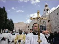  ?? Majdi Mohammed / Associated Press ?? Catholic clergy walk in procession from the Church of the Nativity, traditiona­lly believed to be the birthplace of Jesus Christ, during Christmas festivitie­s on Friday in Bethlehem.
