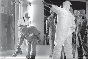  ?? AP/DANIEL CHAN ?? A Malaysian hazardous-materials team scans the area of Kuala Lumpur Internatio­nal Airport today where the half brother of North Korea’s leader was poisoned.