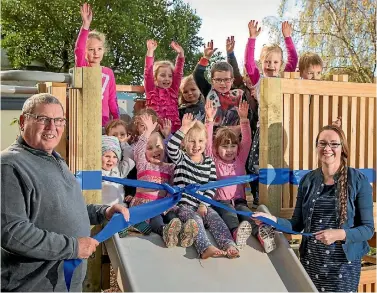  ?? PHOTO: MYTCHALL BRANSGROVE/FAIRFAX NZ ?? Greg Clapp and Kathryn Bennet open the new playground with pupils of Rhona Day Kindergart­en.