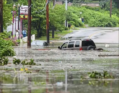  ?? Stephanie Strasburg/ Post- Gazette ?? Two cars are submerged by floodwater­s Thursday along Route 130 in Penn Hills.