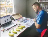  ?? Westside Eagle Observer/SUSAN HOLLAND ?? Barry Hastings, manager at the Rogers Best Buy store, looks through a book of sample circuits that can be constructe­d on the Snap Circuits Junior grid at the Gravette Public Library’s STEAM @ The Library kickoff event Friday, Aug. 23. To Hastings’ left is a banana piano built using a Makey Makey circuit board. Both machines will be used in the library’s Tech Tuesday events beginning Monday, Sept. 9.