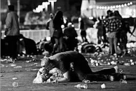  ?? DAVID BECKER/GETTY ?? A man checks on a woman Sunday night in Las Vegas, where a gunman opened fire.