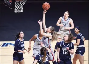  ?? Jessica Hill / Associated Press ?? UConn’s Paige Bueckers, center, shoots as Villanova’s Bella Runyan (32) defends during the first half of the Big East tournament semifinals on Sunday at Mohegan Sun Arena in Uncasville.