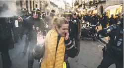  ??  ?? Riot police disperse protesters with tear gas as they try to demonstrat­e near the presidenti­al Elysee Palace in Paris on Saturday.