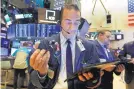  ?? RICHARD DREW/ASSOCIATED PRESS ?? Trader Gregory Rowe works on the floor of the New York Stock Exchange. Wall Street is enjoying its third record-setting run of the year.