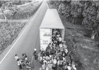  ?? Guillermo Arias / AFP / Getty Images ?? Honduran migrants, part of a caravan heading to the U.S., board a truck Friday in southern Mexico. The U.S. is expected to deploy troops to the border to help tackle a “national emergency.”