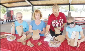  ?? LYNN KUTTER ENTERPRISE-LEADER ?? Arlene Stilwell, left, Diane Bryant, Jill Simpson and Judy Horne, all members of Farmington Garden Club, place daffodil bulbs in bags. The club will give away free bulbs to visitors at the Farmington Fall Festival on Saturday at Creekside Park in Farmington.