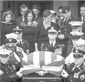  ?? AGEnCE FRanCE PRESSE ?? Cindy McCain holds hands with her son James McCain as they follow a joint military service casket team carrying the late Senator John McCain following his funeral service at the Washington National Cathedral yesterday.