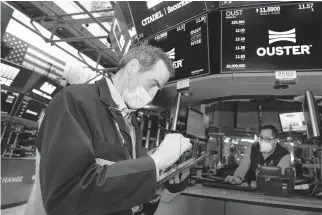  ?? EXCHANGE/ AP
NICOLE PEREIRA/NEW YORK STOCK ?? Trader Gregory Rowe, left, works on the trading floor March 12, 2021, in New York.
