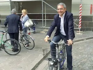  ??  ?? Pedalata Dieter Steger, appena uscito dal vertice, inforca la bici davanti al municipio