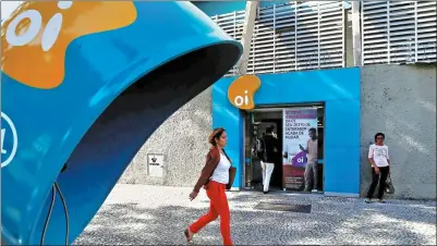  ?? REUTERS ?? People walk in front of the headquarte­rs of the Brazil's largest fixed-line telecoms group Oi in Rio de Janeiro, Brazil.