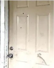  ?? STAFF PHOTO BY ROSANA HUGHES ?? Bullet holes can be seen in the door of a Dodson Avenue home after an early Sunday morning shooting.